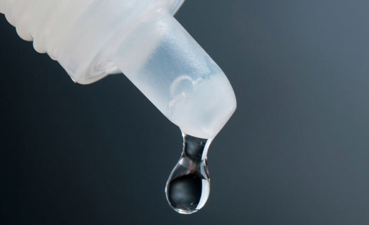 Close-up of a drip coming from a eyedrops bottle