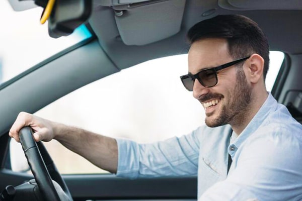 Man wearing sunglasses driving a car