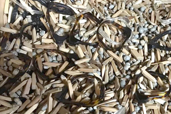Glasses frame parts mixed with wood chips and pumice stones