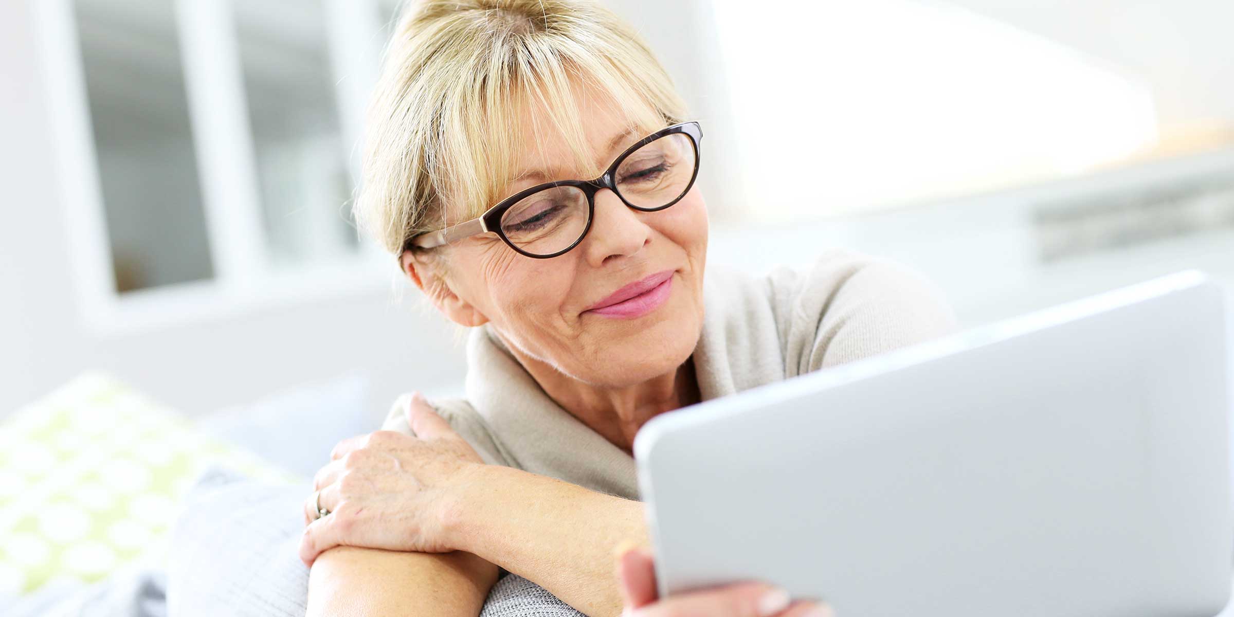 Older woman with glasses looking at a tablet