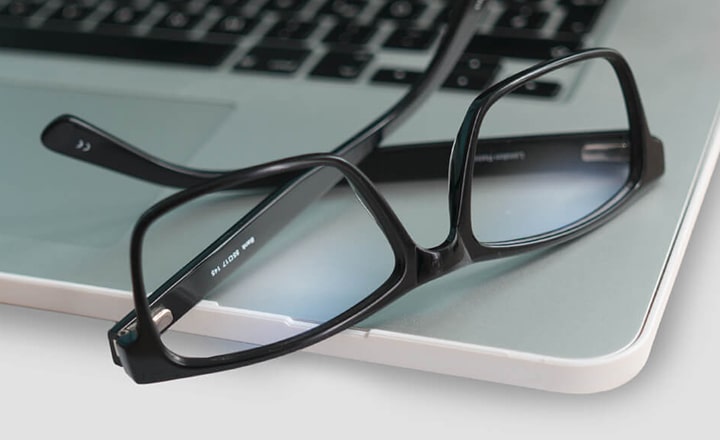 Black glasses lying on a laptop
