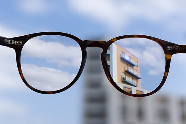 View of a building through a pair of glasses. Only the parts seens through the lenses are sharp, the rest of the image is blurry.