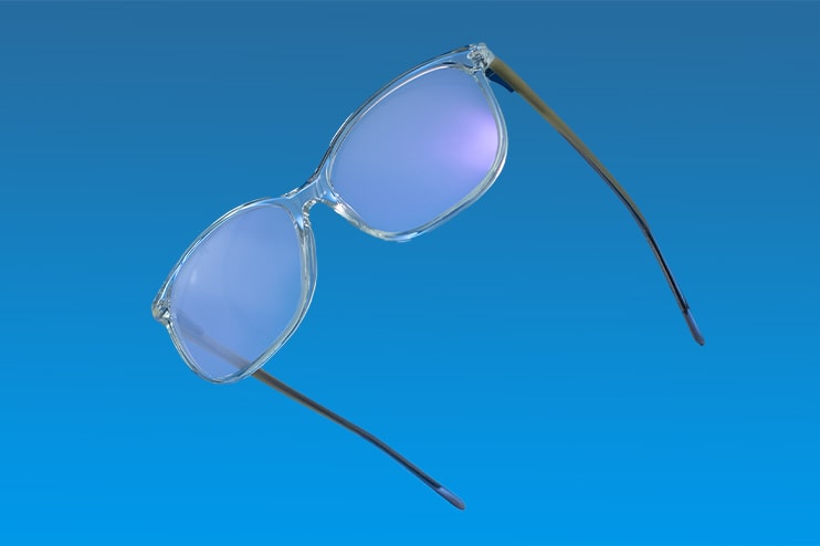 A pair of glasses with coated lenses in front of a blue background