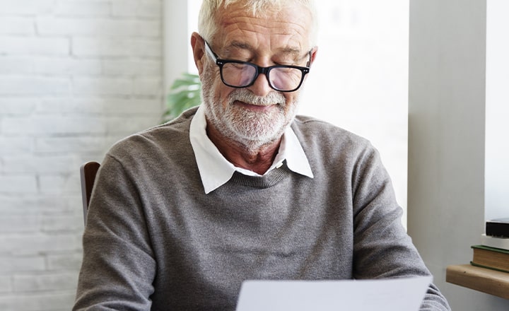 An older man reading through glasses