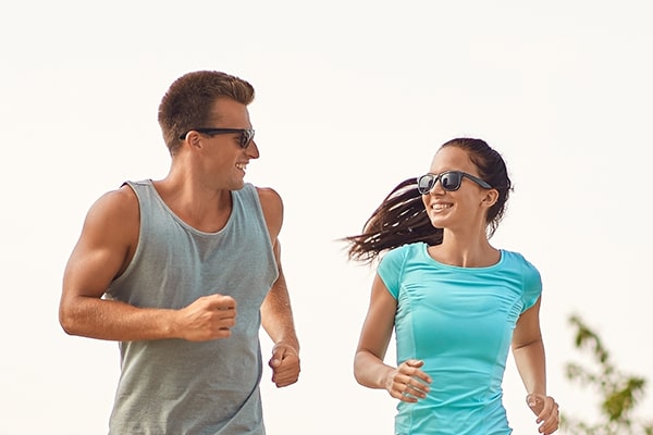 Couple in sunglasses running