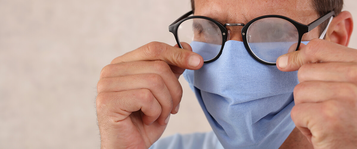 Man with face mask wearing fogged up glasses