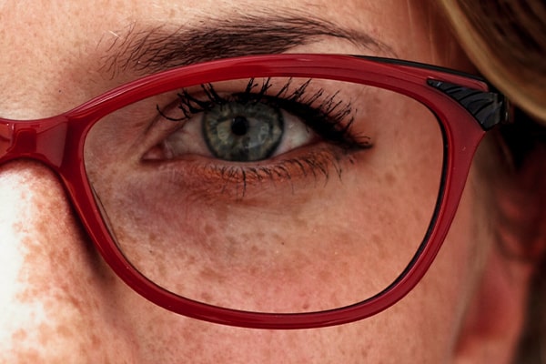 Close-up of the eye of a woman wearing red glasses