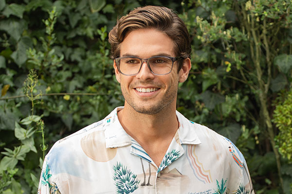 Smiling man with glasses in a garden