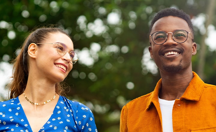 Happy man and woman wearing glasses outdoors