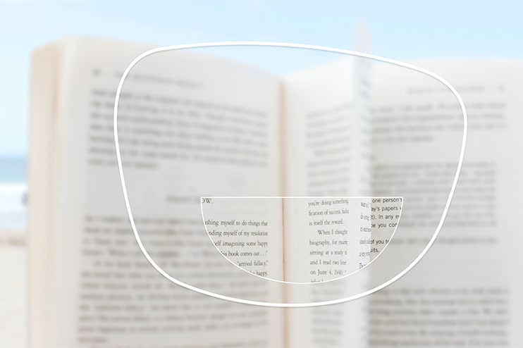 A book viewed through a bifocal lens, with only the reading segment in focus