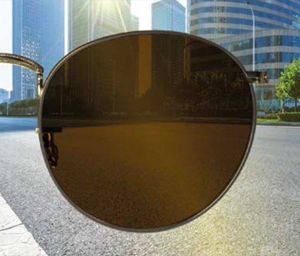 Transitions Drivewear lens with a dark brown tint in bright sunlight