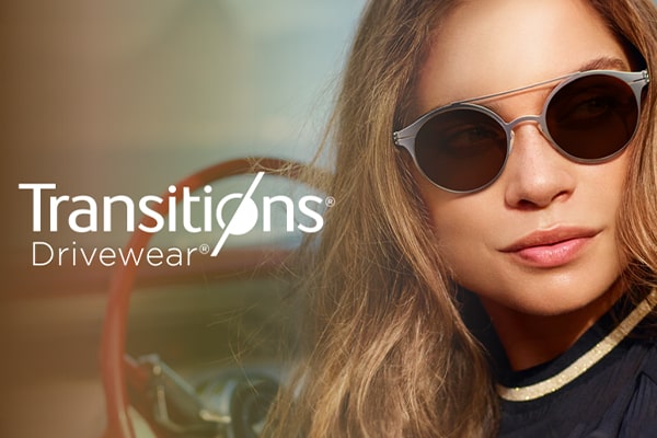Woman wearing Transitions Drivewear sunglasses behind the wheel of her car