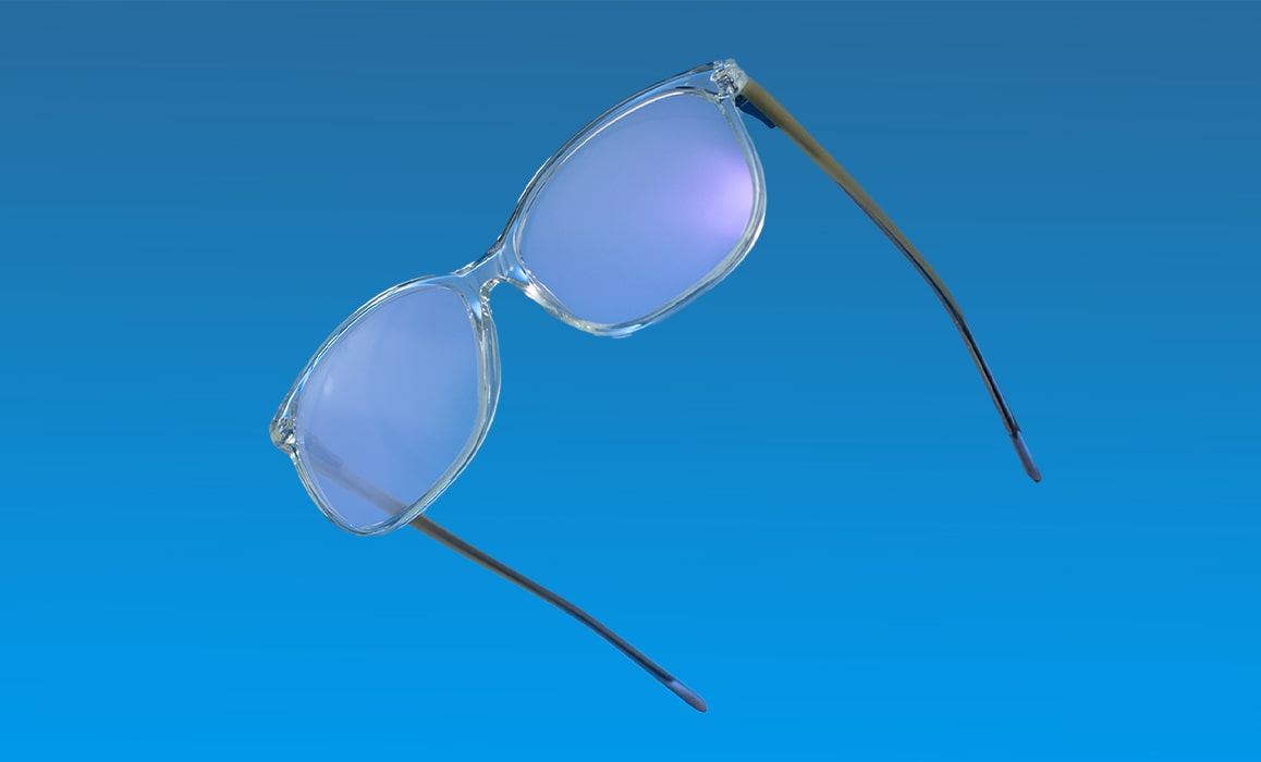 A pair of glasses with coated lenses in front of a blue background