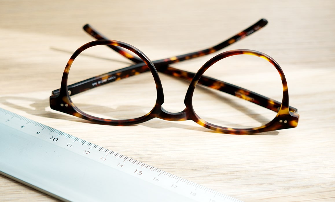 A pair of glasses next to a ruler