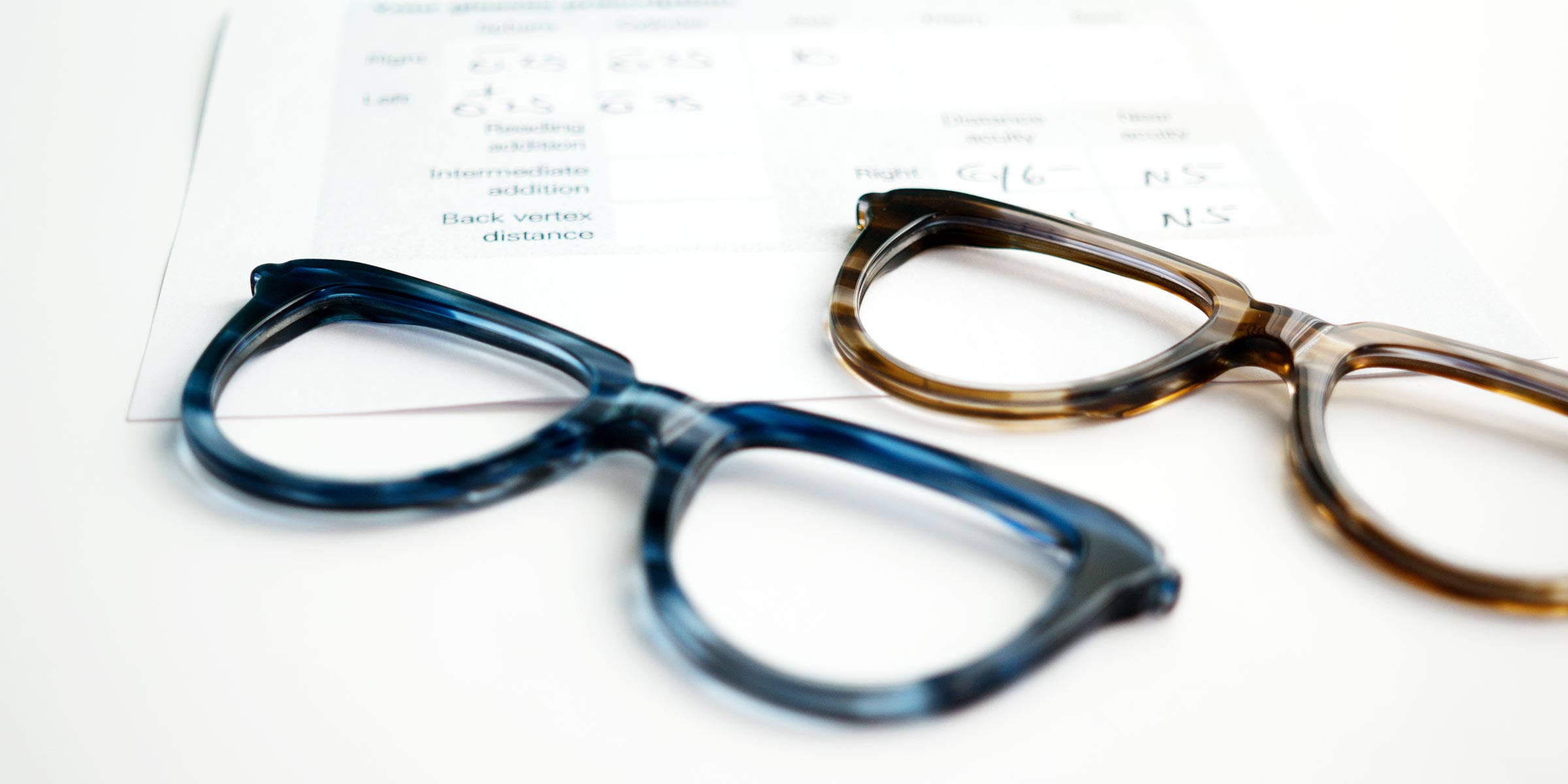 Glasses frames lying next to a prescription form