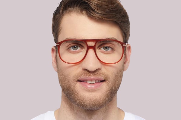 Man with brown hair and a beard wearing red plastic aviator frames